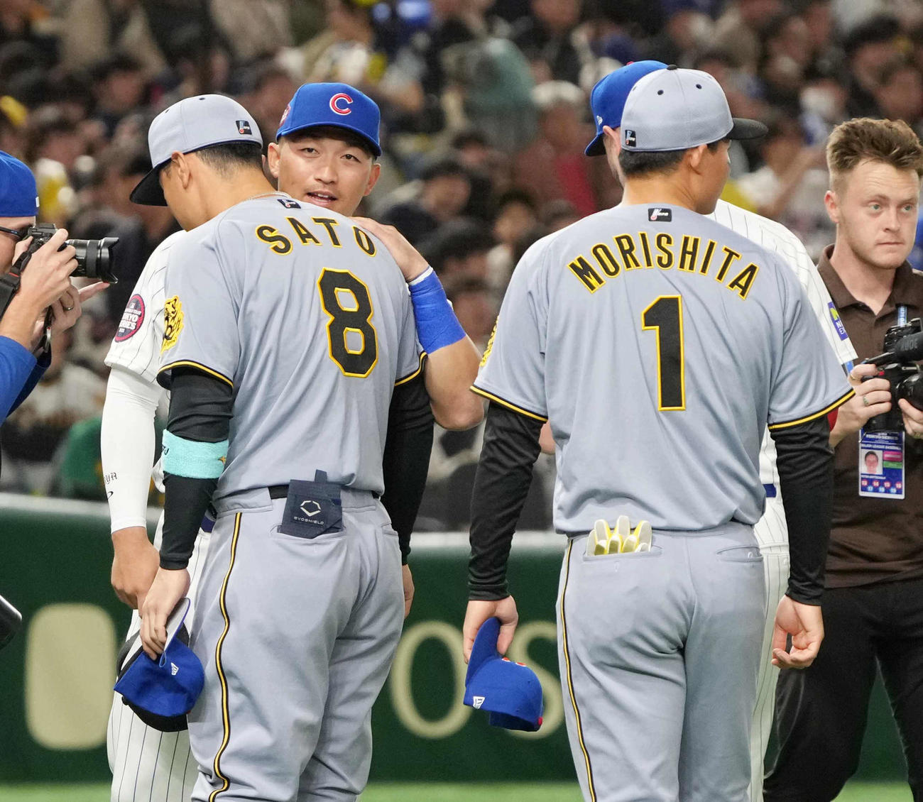 阪神対カブス　試合前のセレモニーでカブス鈴木から声を掛けられる阪神佐藤輝（中央）。右は森下（撮影・小沢裕）