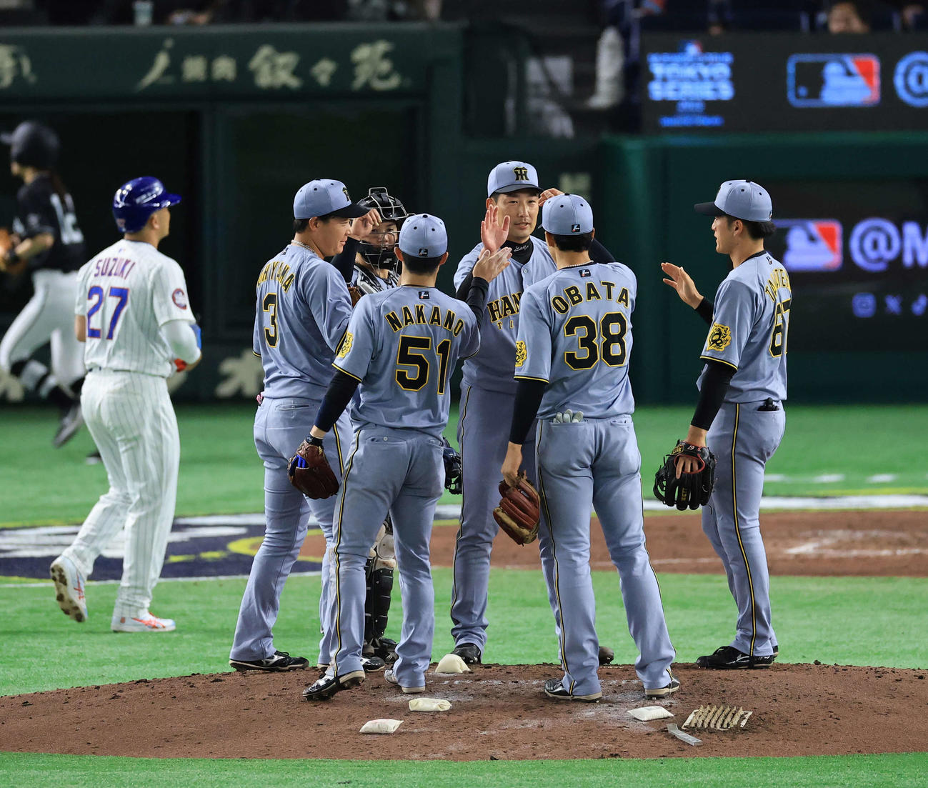阪神対カブス　3－0で勝利し、ハイタッチで喜び合う岩崎（中央）ら阪神の選手立ち。奥は鈴木（撮影・浅見桂子）