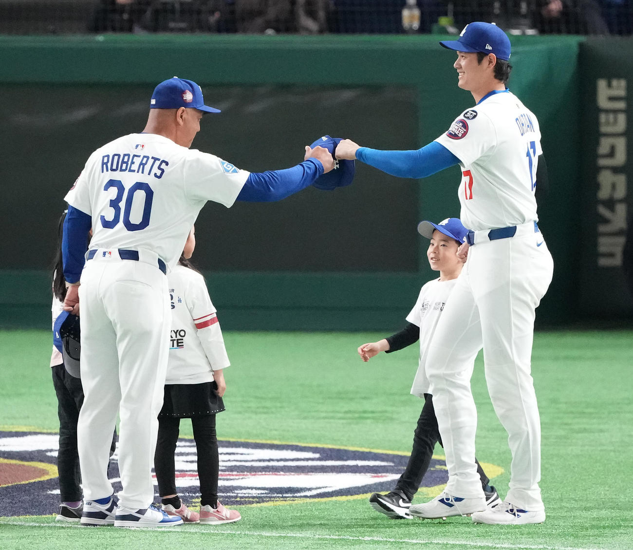 阪神対ドジャース　試合前セレモニーに登場し、ロバーツ監督（左）とタッチを交わすドジャース大谷（撮影・鈴木みどり）