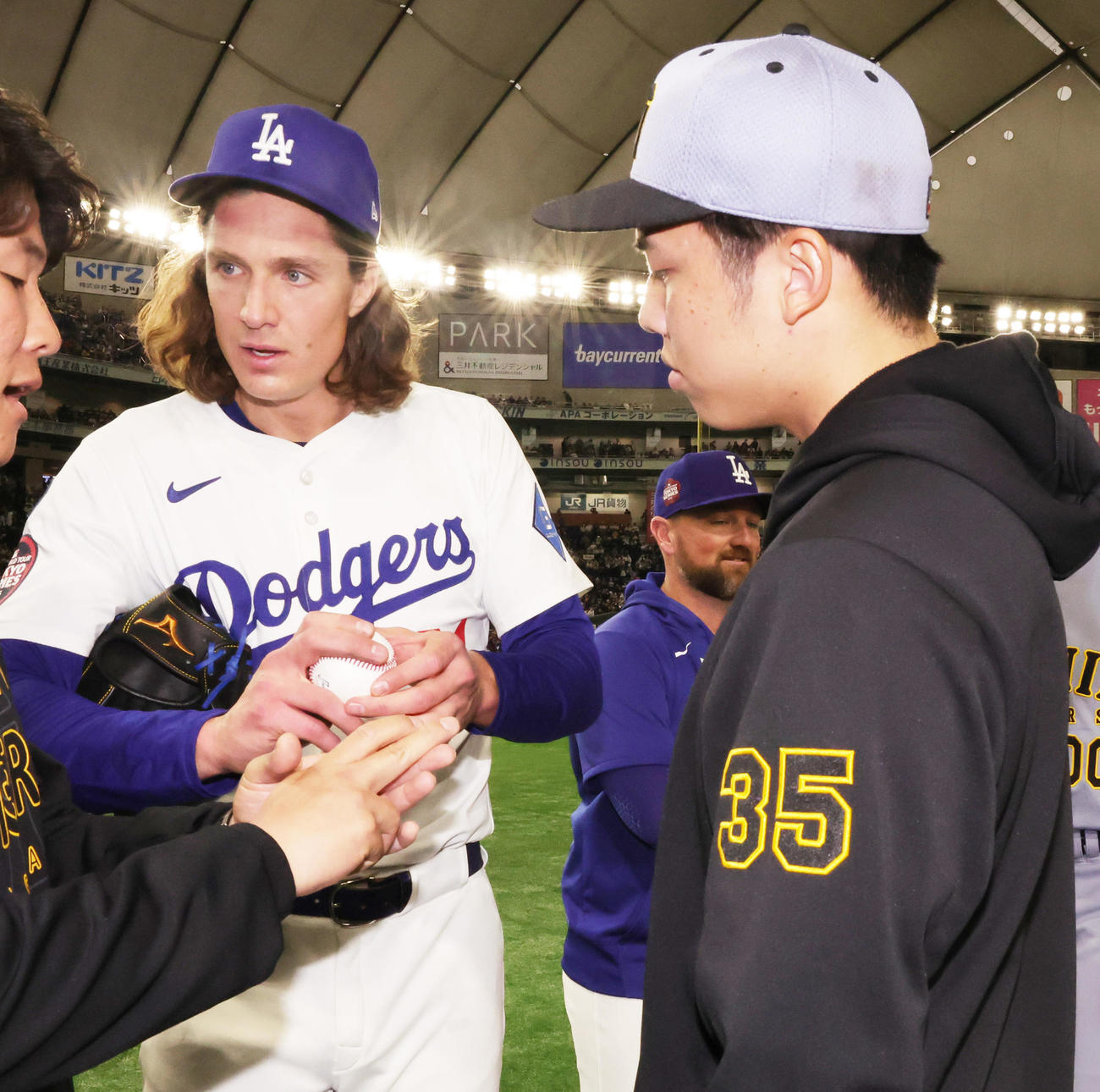 阪神対ドジャース　試合後にボールの握りについて話をするドジャースのグラスノー（左）と阪神才木（撮影・野上伸悟）
