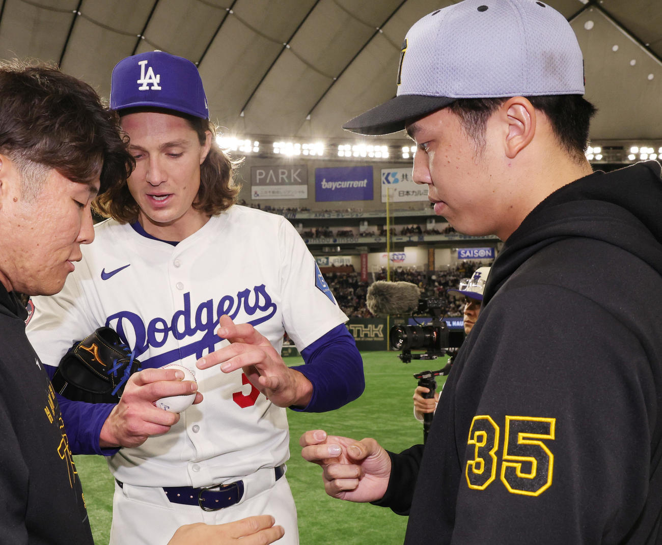 阪神対ドジャース　試合後にボールの握りについて話をするドジャースのグラスノー（左）と阪神才木（撮影・野上伸悟）