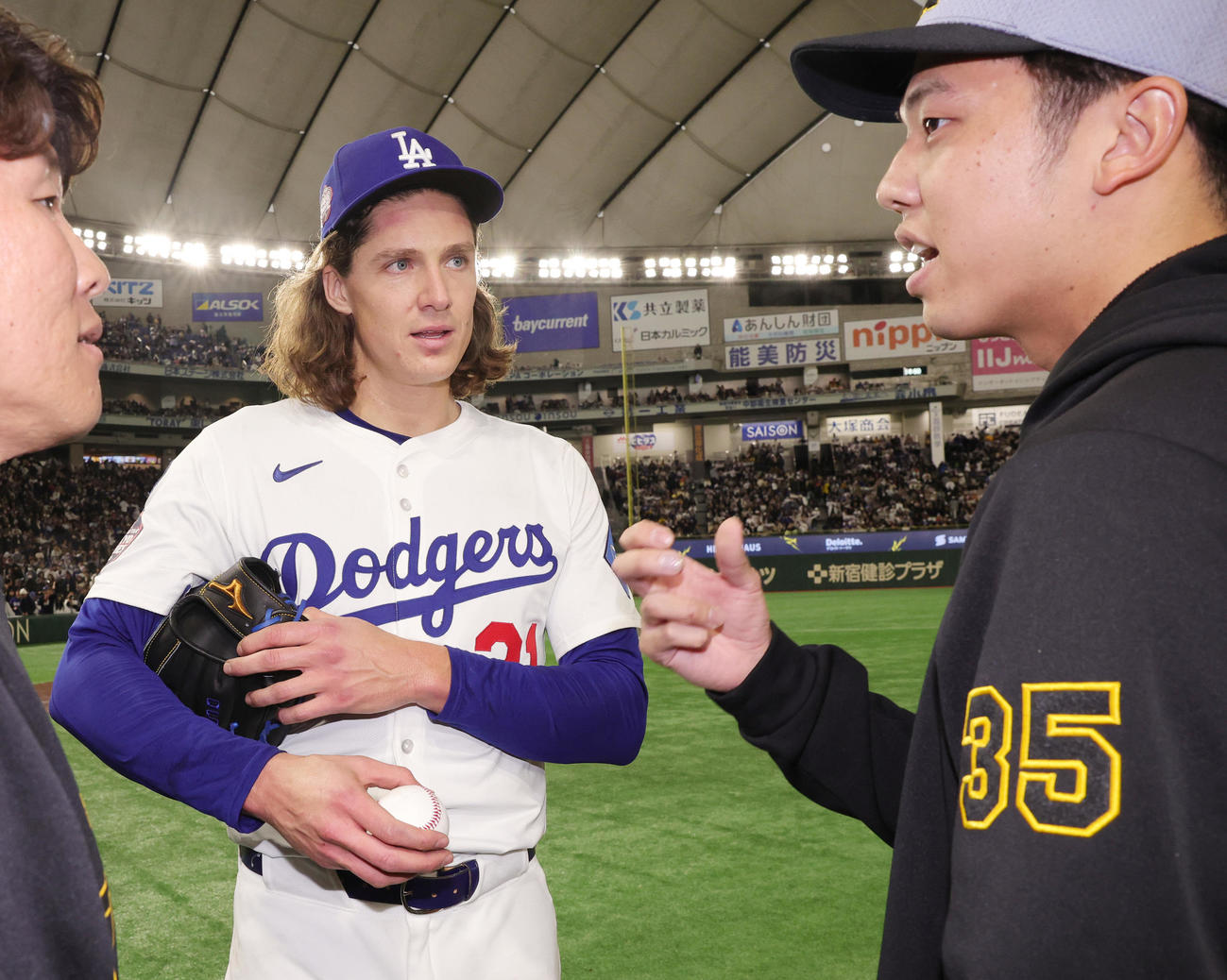 阪神対ドジャース　試合後にボールの握りについて話をするドジャースのグラスノー（左）と阪神才木（撮影・野上伸悟）