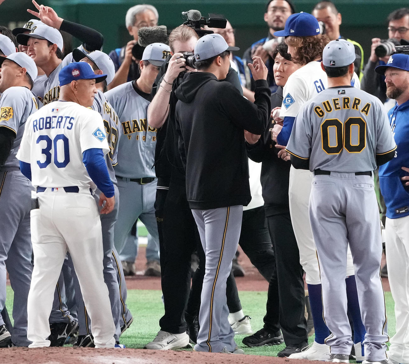阪神対ドジャース　試合後、ドジャースのグラスノー（右から3人目）と話す阪神才木（中央）。左手前はロバーツ監督（撮影・鈴木みどり）