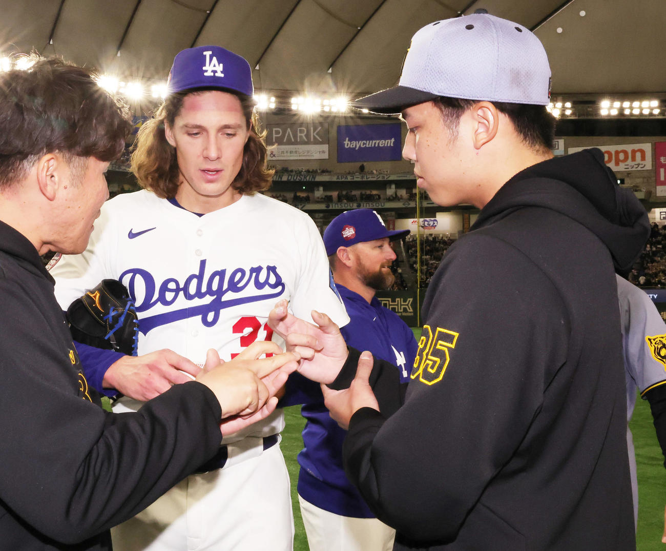 阪神対ドジャース　試合後にボールの握りについて話をするドジャースのグラスノー（左）と阪神才木（撮影・野上伸悟）