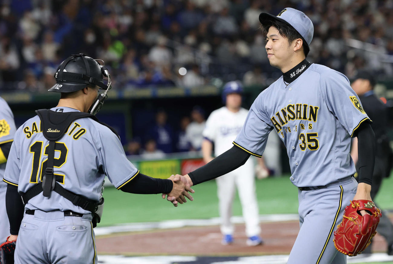 阪神対ドジャース　1回表を3者凡退で終え坂本（左）と握手する才木（撮影・野上伸悟）