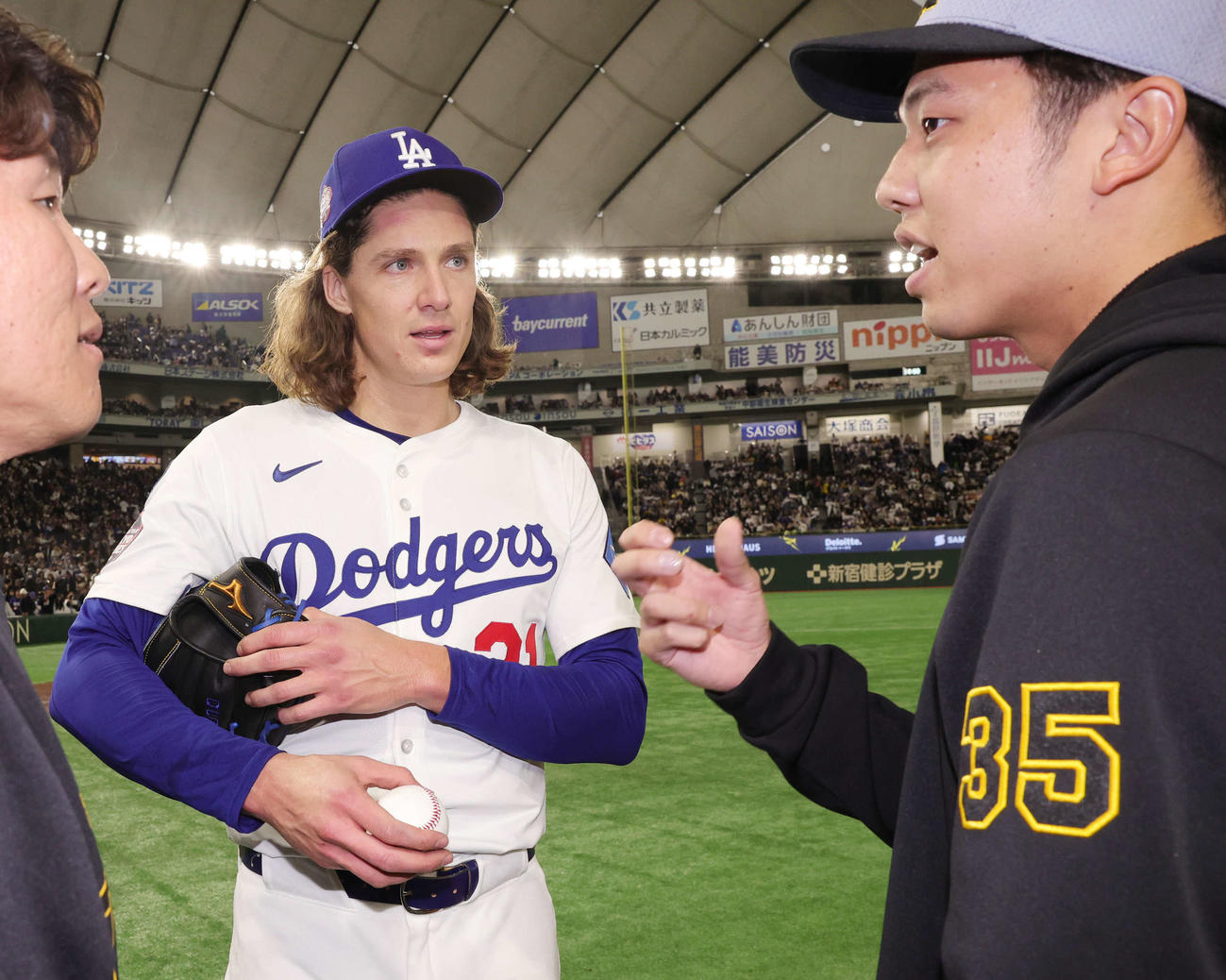 阪神対ドジャース　試合後にボールの握りについて話をするドジャースのグラスノー（左）と阪神才木（撮影・野上伸悟）