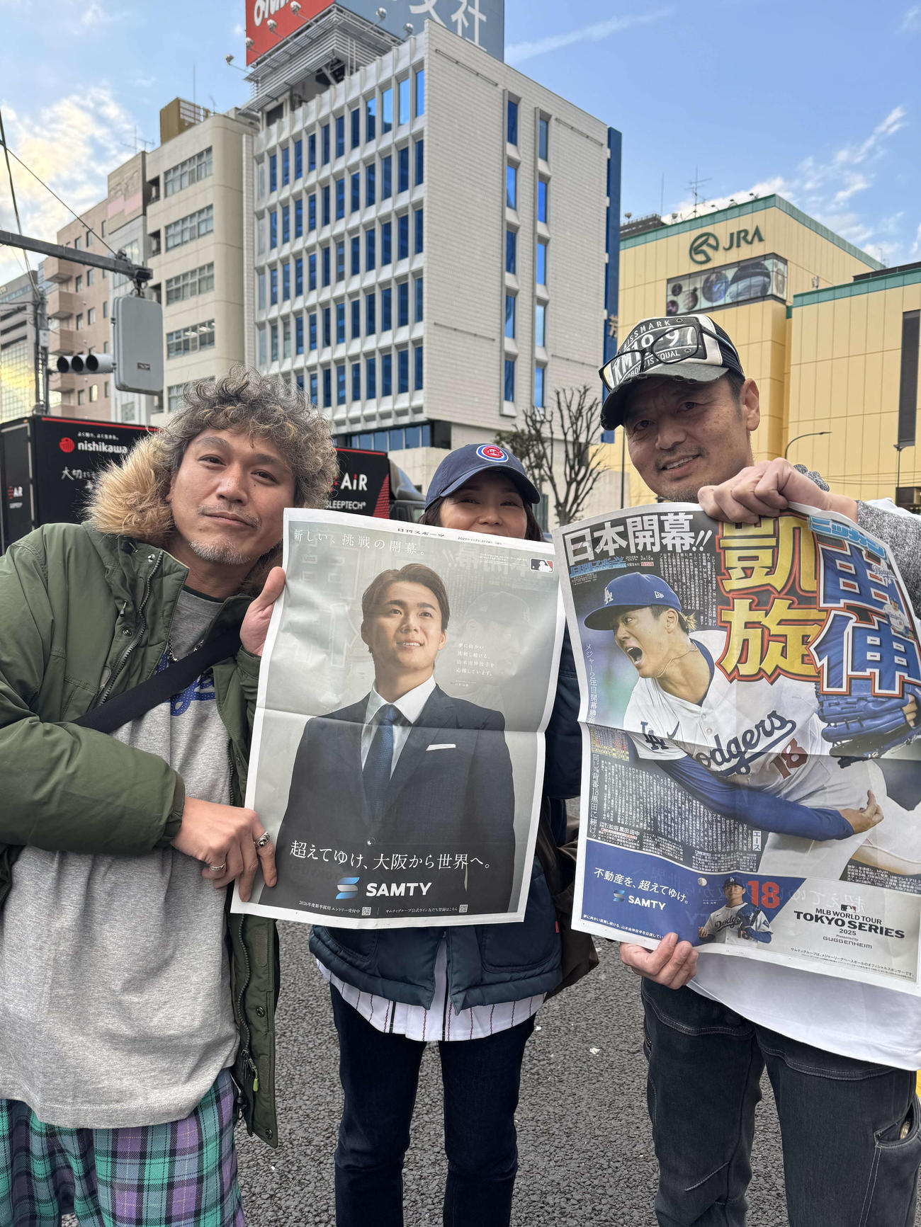 日刊スポーツが配布した号外を手に笑顔を見せるファン