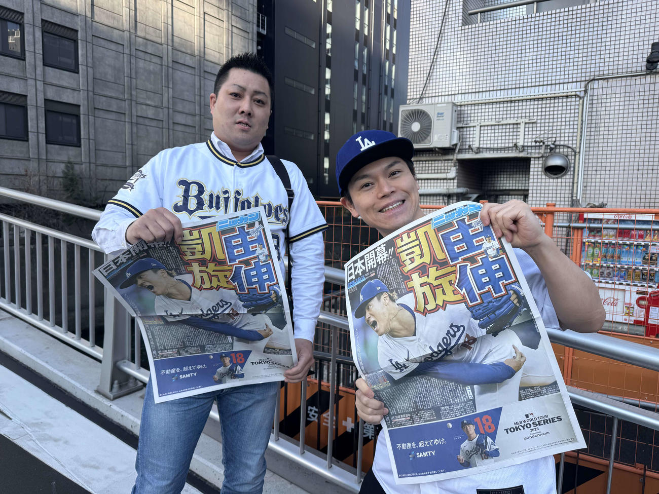 日刊スポーツが配布した号外を手に笑顔を見せるファン