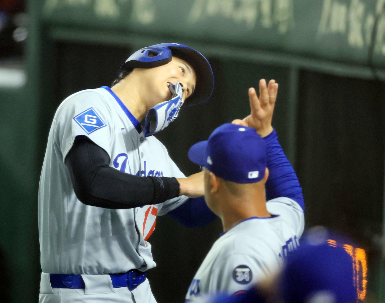 カブス対ドジャース　5回表ドジャース1死一、三塁、T・ヘルナンデスの打撃で生還した大谷は笑顔のポーズでロバーツ監督とハイタッチ（撮影・浅見桂子）
