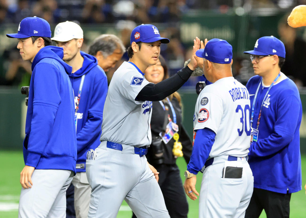 カブス対ドジャース　開幕戦勝利を飾り、ドジャースのロバーツ監督（右）らとハイタッチで喜び合う大谷（中央）。左は佐々木（撮影・浅見桂子）