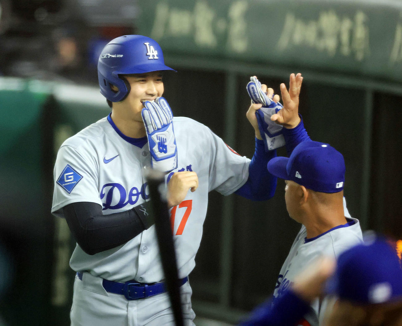 カブス対ドジャース　5回表ドジャース1死一、三塁、T・ヘルナンデスの打撃で生還した大谷は笑顔でロバーツ監督とハイタッチ（撮影・浅見桂子）