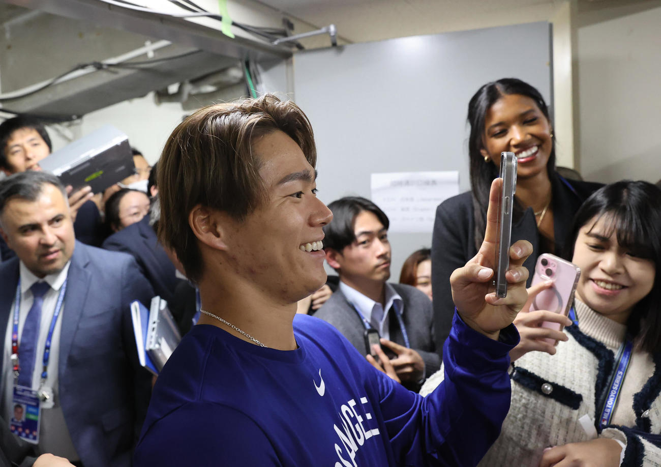 試合後、会見に臨む大谷をスマートフォンで撮影するドジャースの山本（代表撮影）
