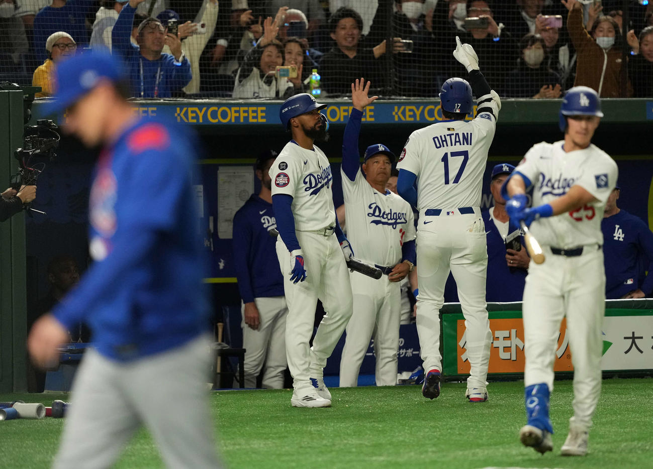 カブス対ドジャース　5回裏ドジャース1死、右中間に本塁打を放った大谷（手前）はロバーツ監督（奥）の出迎えを受ける（撮影・井上学）