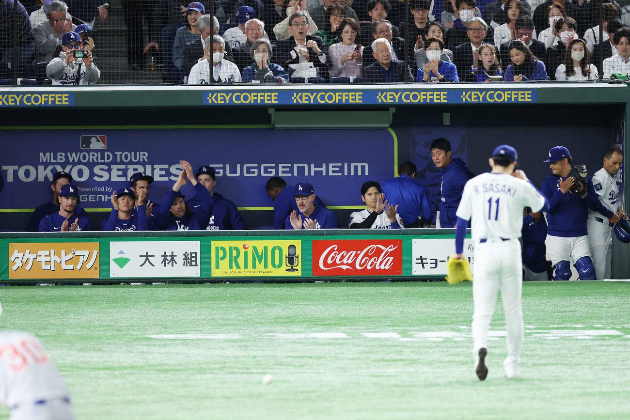 カブス対ドジャース　1回裏を3者凡退に抑えたドジャース佐々木（手前）に拍手する山本（左から3人目）と大谷（同9人目）ら（撮影・宮地輝）