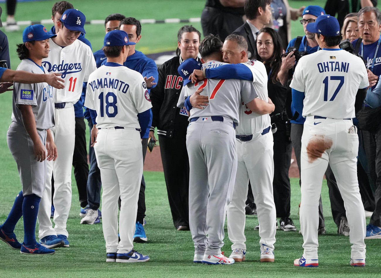 カブス対ドジャース　試合後、カブス鈴木（中央手前）とハグするドジャースのロバーツ監督（中央）（撮影・鈴木みどり）