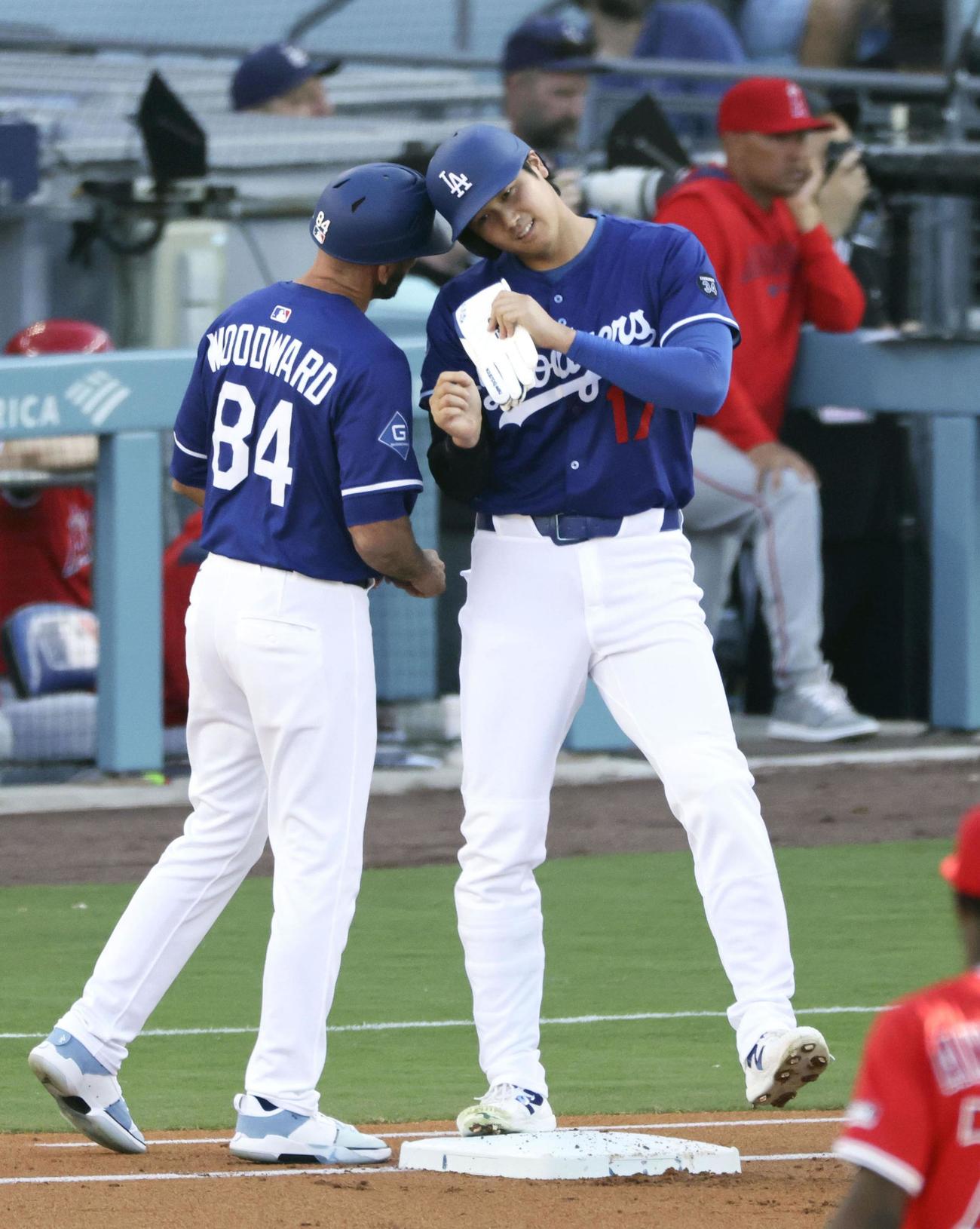 エンゼルス戦の1回、四球を選び一塁コーチとヘルメットを合わせるドジャース大谷（共同）