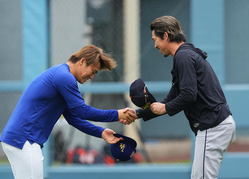 ドジャース対タイガース　試合前、タイガース前田（右）に握手であいさつするドジャース山本（撮影・菅敏）