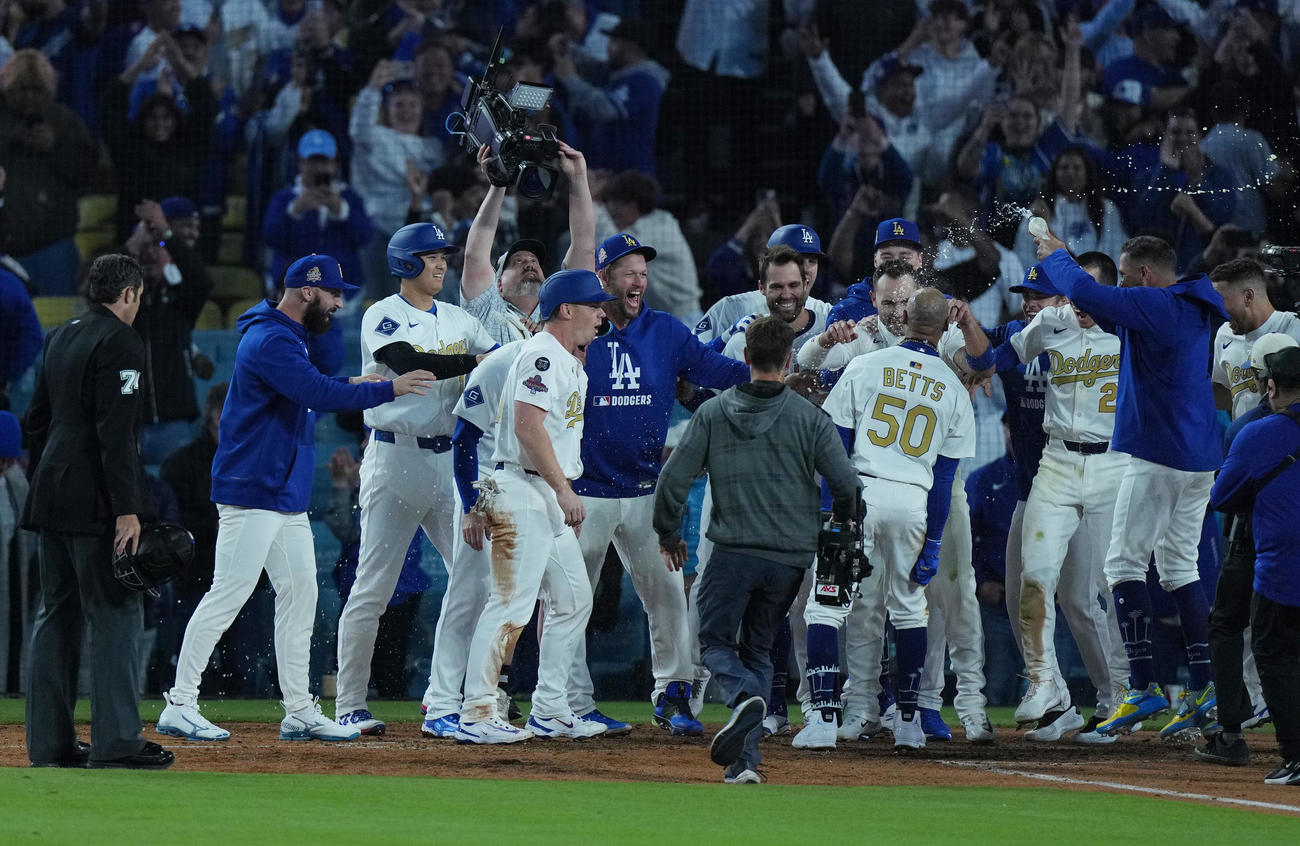ドジャース対タイガース　10回裏ドジャース1死二、三塁、サヨナラの3点本塁打を放ち歓喜の輪の中に飛び込むベッツ（中央右）を笑顔で迎える大谷（左から2人目）（撮影・菅敏）