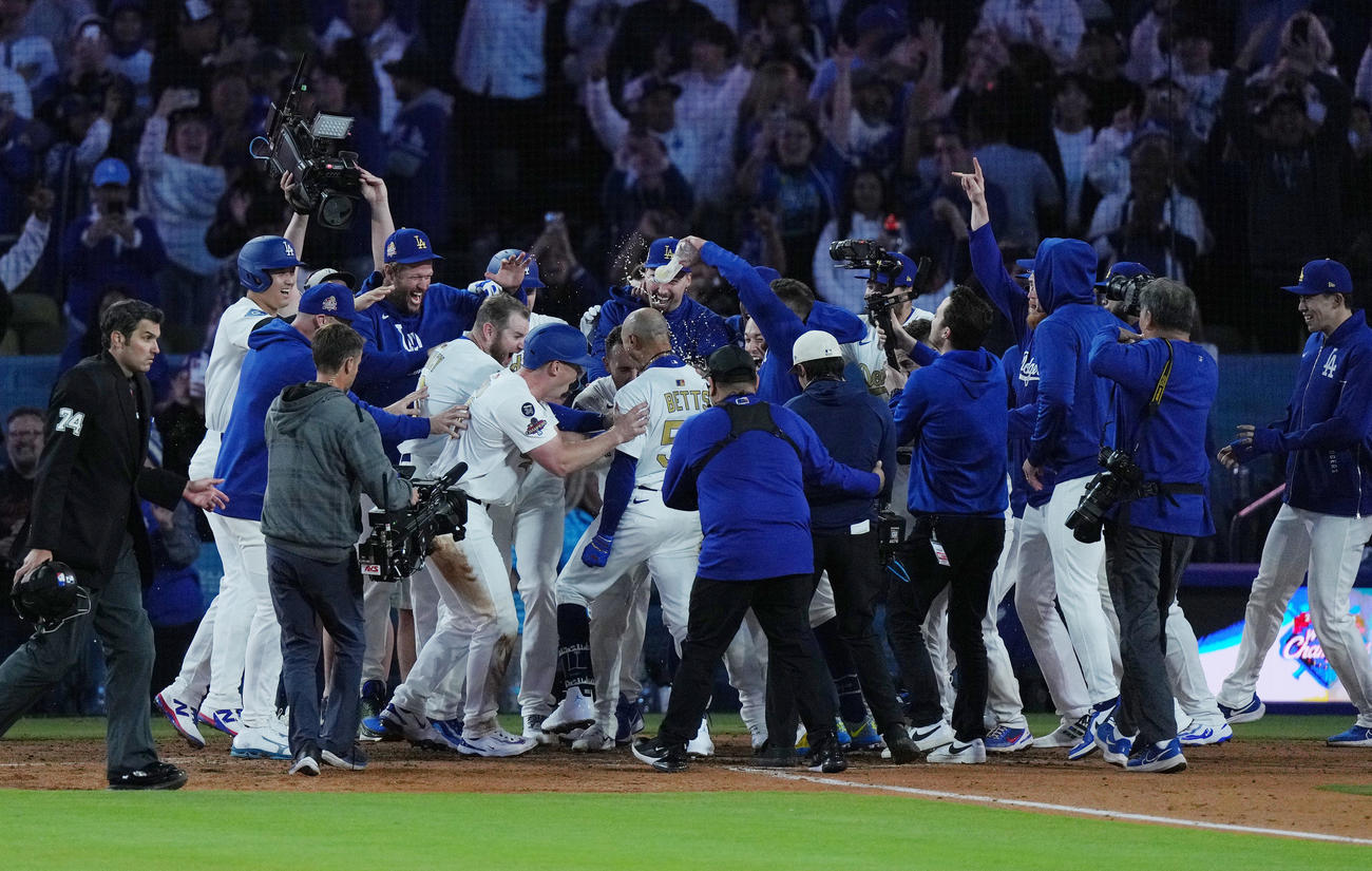 ドジャース対タイガース　10回裏ドジャース1死二、三塁、サヨナラの3点本塁打を放ち歓喜の輪の中に飛び込むベッツ（中央）を笑顔で迎える大谷（左端）と佐々木（右端）（撮影・菅敏）