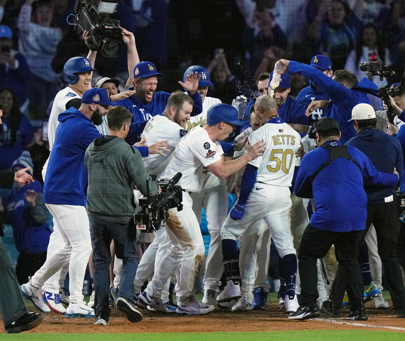 ドジャース対タイガース　10回裏ドジャース1死二、三塁、サヨナラの3点本塁打を放ったベッツ（中央右）を笑顔で迎える大谷（左端）らナイン（撮影・菅敏）