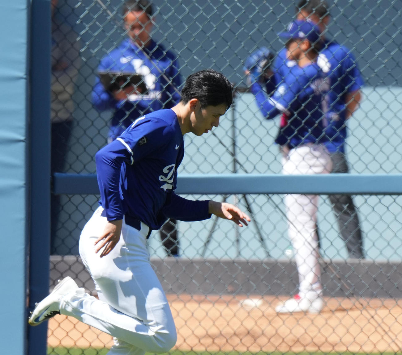 ドジャース対ブレーブス　試合前、ブルペンで投球練習をする山本（後方）を横目に走り込む佐々木（撮影・菅敏）