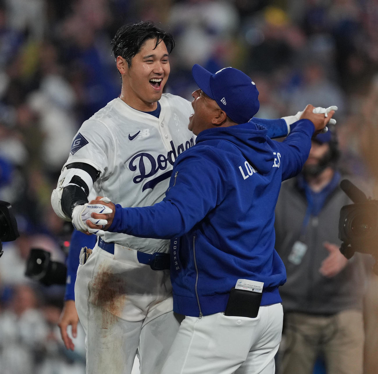 ドジャース対ブレーブス　9回裏ドジャース1死、サヨナラのソロ本塁打を放ち、ロバーツ監督（右）に祝福を受ける大谷（撮影・菅敏）