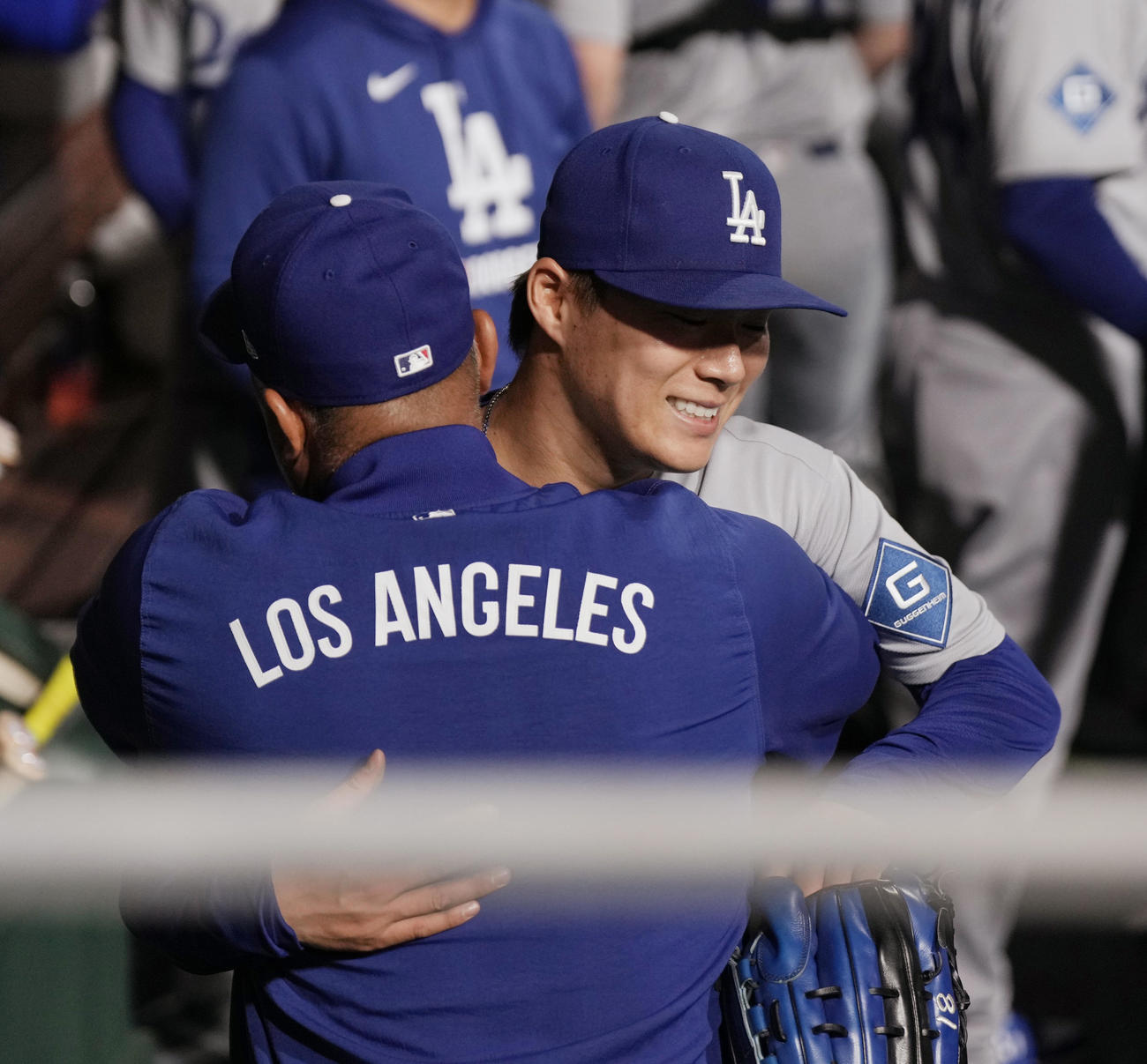フィリーズ対ドジャース　6回の投球を終えたドジャース山本は、ベンチでロバーツ監督（左）にハグで迎えられる（撮影・菅敏）