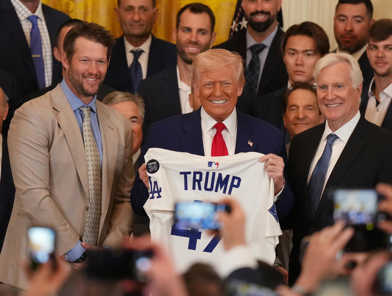 ホワイトハウスを表敬訪問し、受け取ったユニホームを手に笑顔を見せるトランプ大統領。左はドジャース・カーショー、右はオーナーのウォルター氏（撮影・菅敏）
