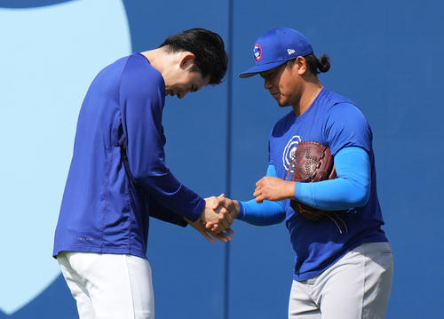ドジャース対カブス　試合前、カブス今永（右）に握手であいさつするドジャース佐々木（撮影・菅敏）
