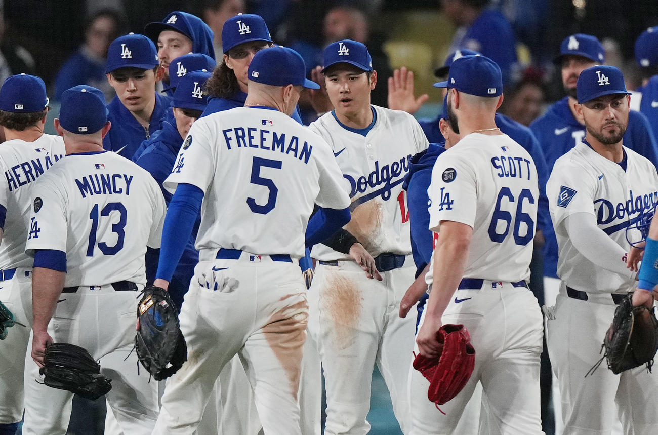 ドジャース対ロッキーズ　ロッキーズに勝利し、フリーマン（中央左）らナインを迎える大谷（撮影・菅敏）