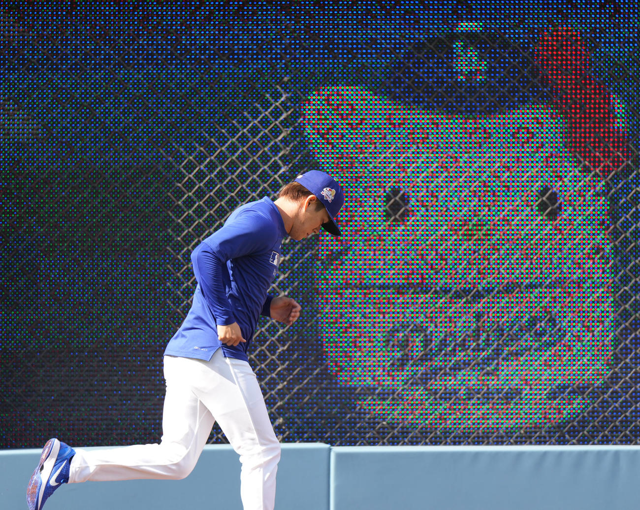ドジャース対ロッキーズ　試合前、電光掲示板に映し出されるキティちゃんを横目にランニングをするドジャース山本（撮影・菅敏）