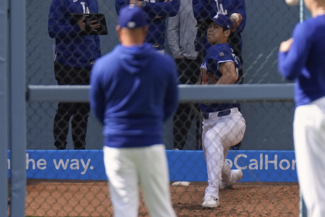 ドジャース大谷翔平（右）はロッキーズとの試合前、ロバーツ監督が見守る中、ブルペンで投球練習（AP)
