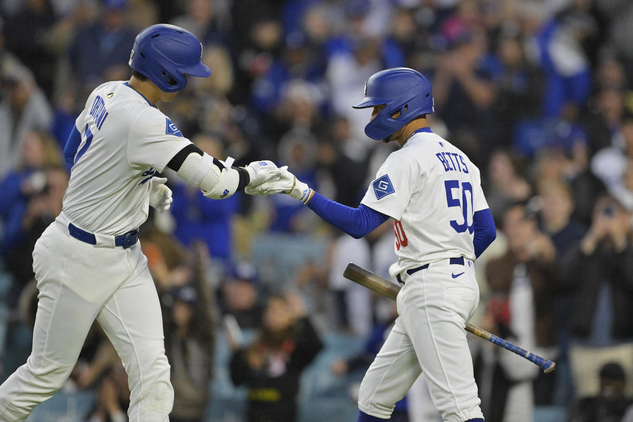 ドジャース大谷翔平（左）はロッキーズ戦の第1打席でソロ本塁打を放ち、同僚のベッツとタッチ（ロイター）