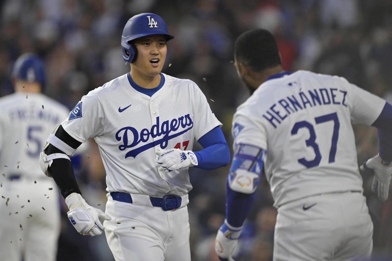 ドジャース大谷翔平（左）はロッキーズ戦の第1打席でソロ本塁打を放ち、同僚のT・ヘルナンデスから祝福を受けた（ロイター）