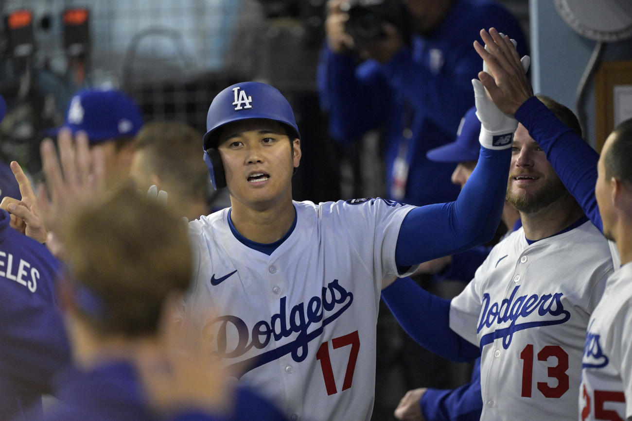 ドジャース大谷翔平はロッキーズ戦の第1打席でソロ本塁打を放ち、ベンチに戻ると同僚から祝福された（ロイター）