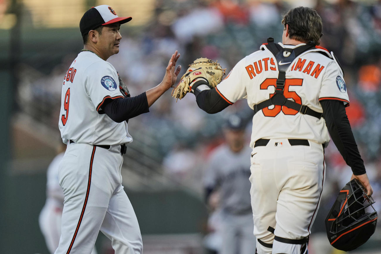オリオールズ菅野智之（左）がヤンキースのペラザから三振を奪った後、ラッチマン捕手とハイタッチ（AP）