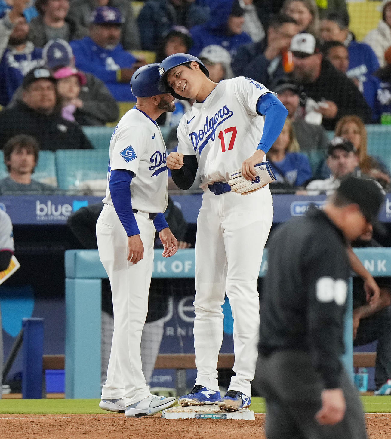 ドジャース対マーリンズ　4回裏ドジャース2死二塁、四球を選び、一塁走塁コーチ（左）とヘッドバンプをする大谷（撮影・菅敏）