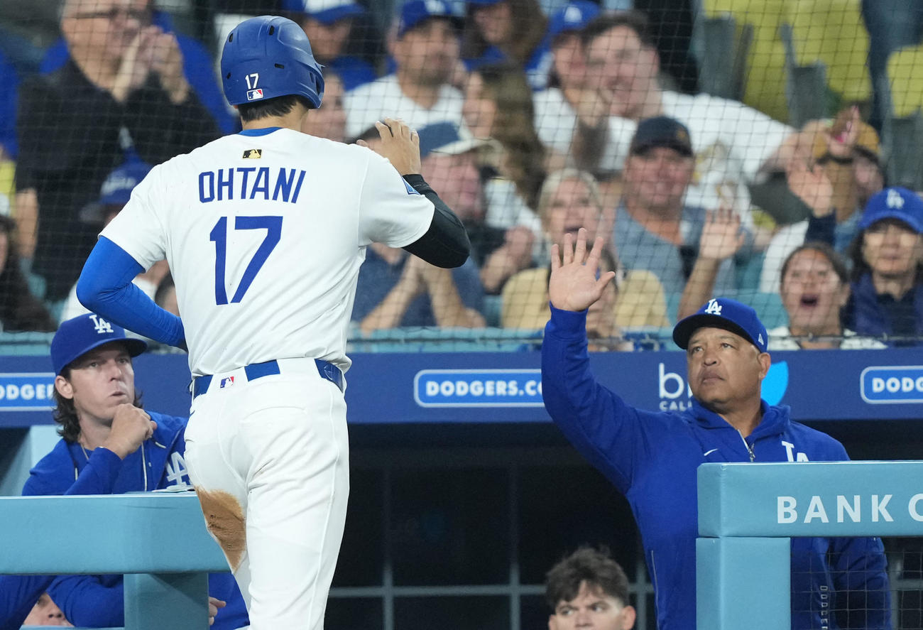 ドジャース大谷翔平（左）はマーリンズ戦2回にホームインしてベンチに帰るとロバーツ監督とハイタッチを交わす（ロイター）