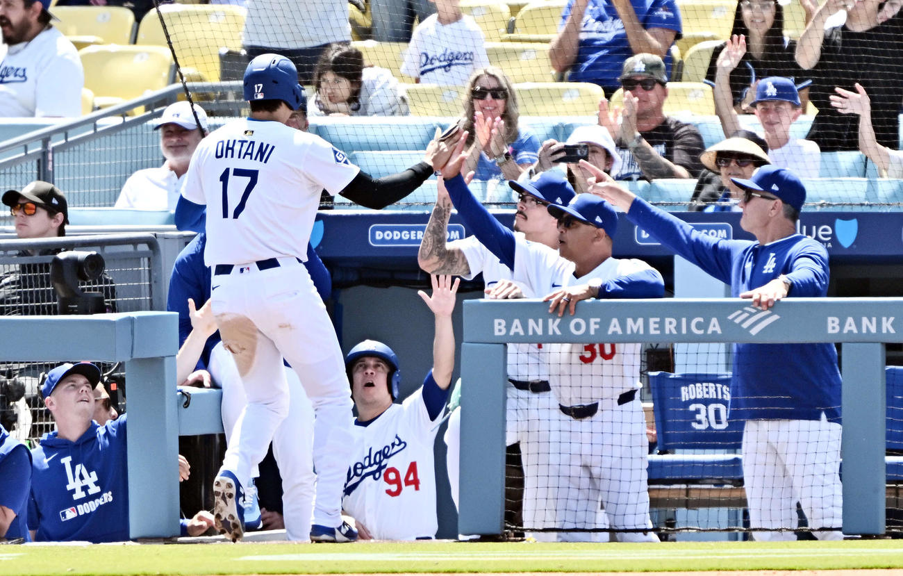 ドジャース対マーリンズ　8回裏ドジャース無死三塁、暴投で生還した大谷（左手前）はロバーツ監督とタッチをかわす（右から2人目）（撮影・滝沢徹郎）