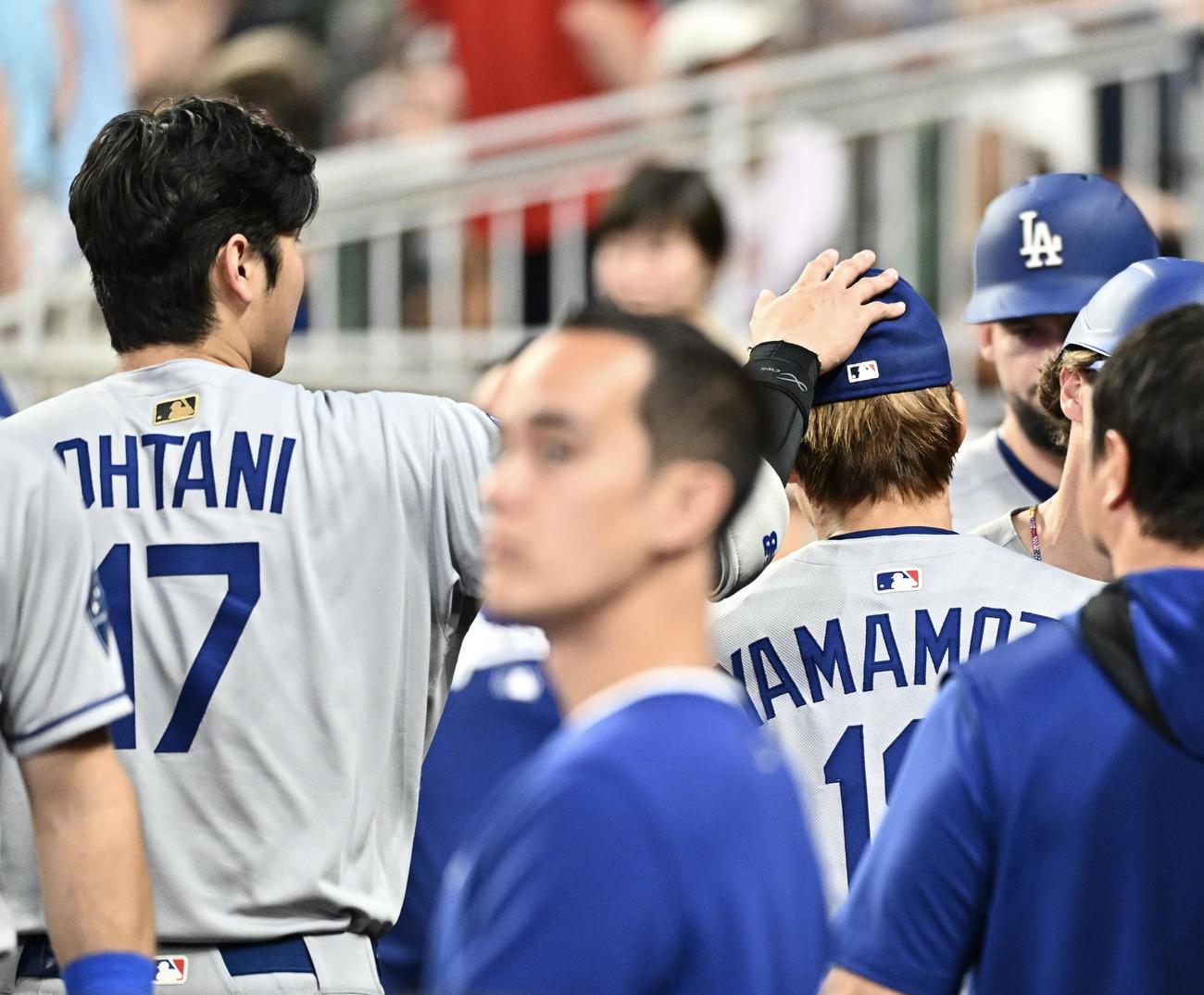 ブレーブス対ドジャース　6回が終わりベンチでドジャース大谷（左）は先発の山本の頭をなでる（撮影・滝沢徹郎）