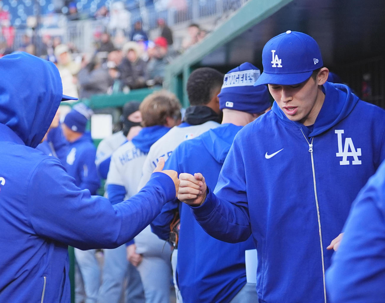 ナショナルズ対ドジャース　試合前、ベンチで山本（左）とタッチをするドジャース佐々木（2025年4月8日撮影）