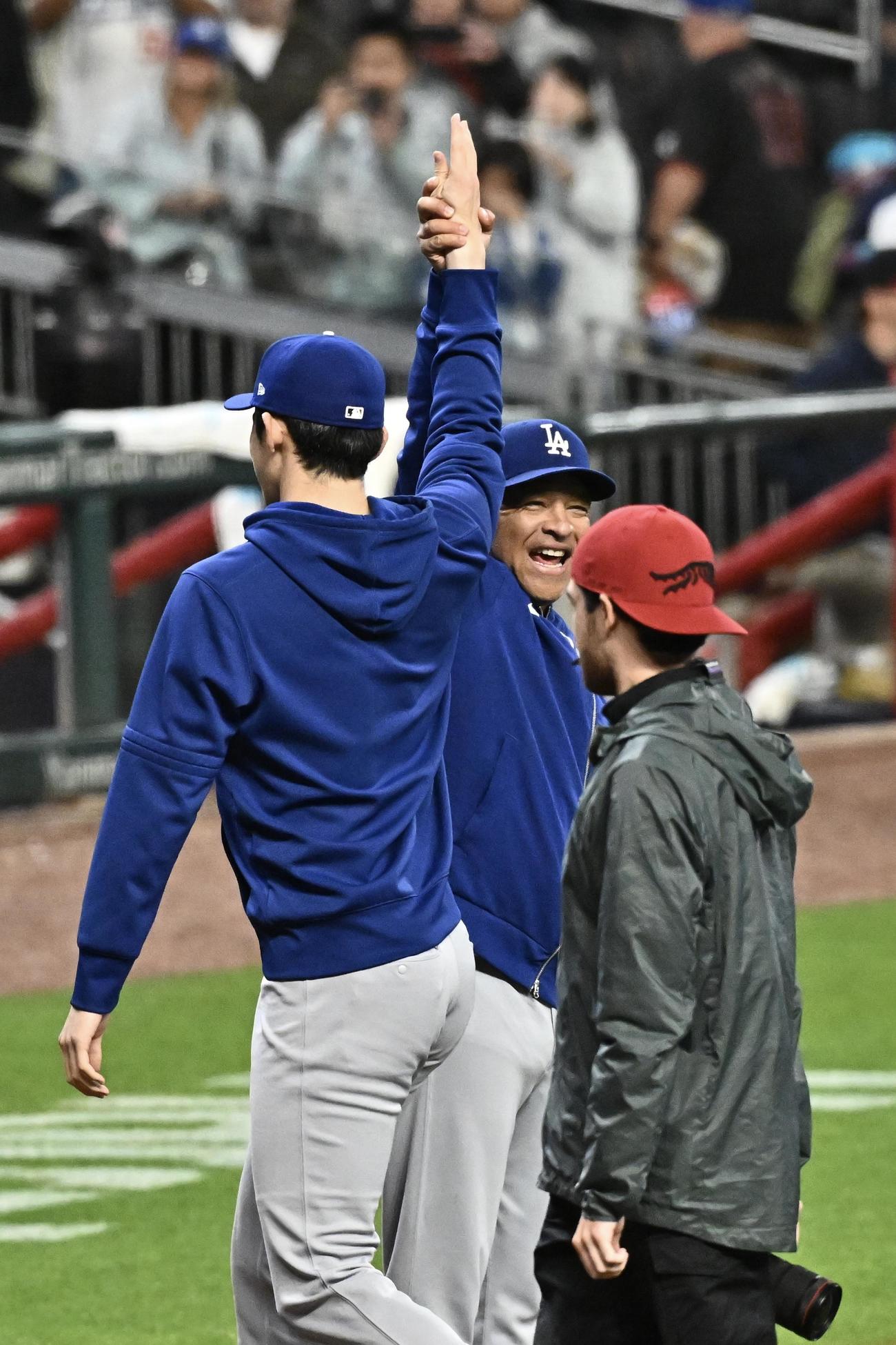 ブレーブス対ドジャース　試合後、メジャー初勝利のドジャース佐々木（左）とハイタッチをかわすロバーツ監督