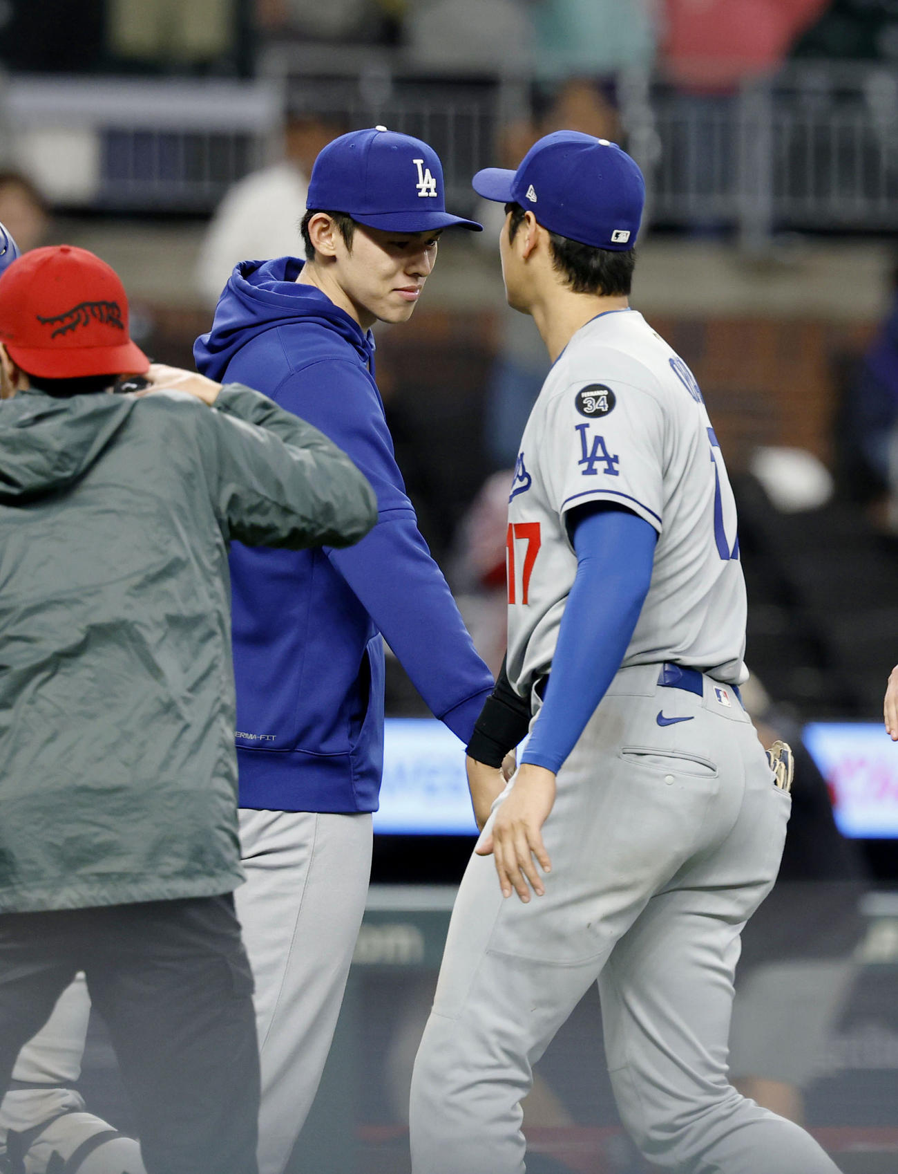 ブレーブス戦でメジャー初勝利を挙げ、大谷（右）とタッチを交わすドジャース・佐々木（共同）