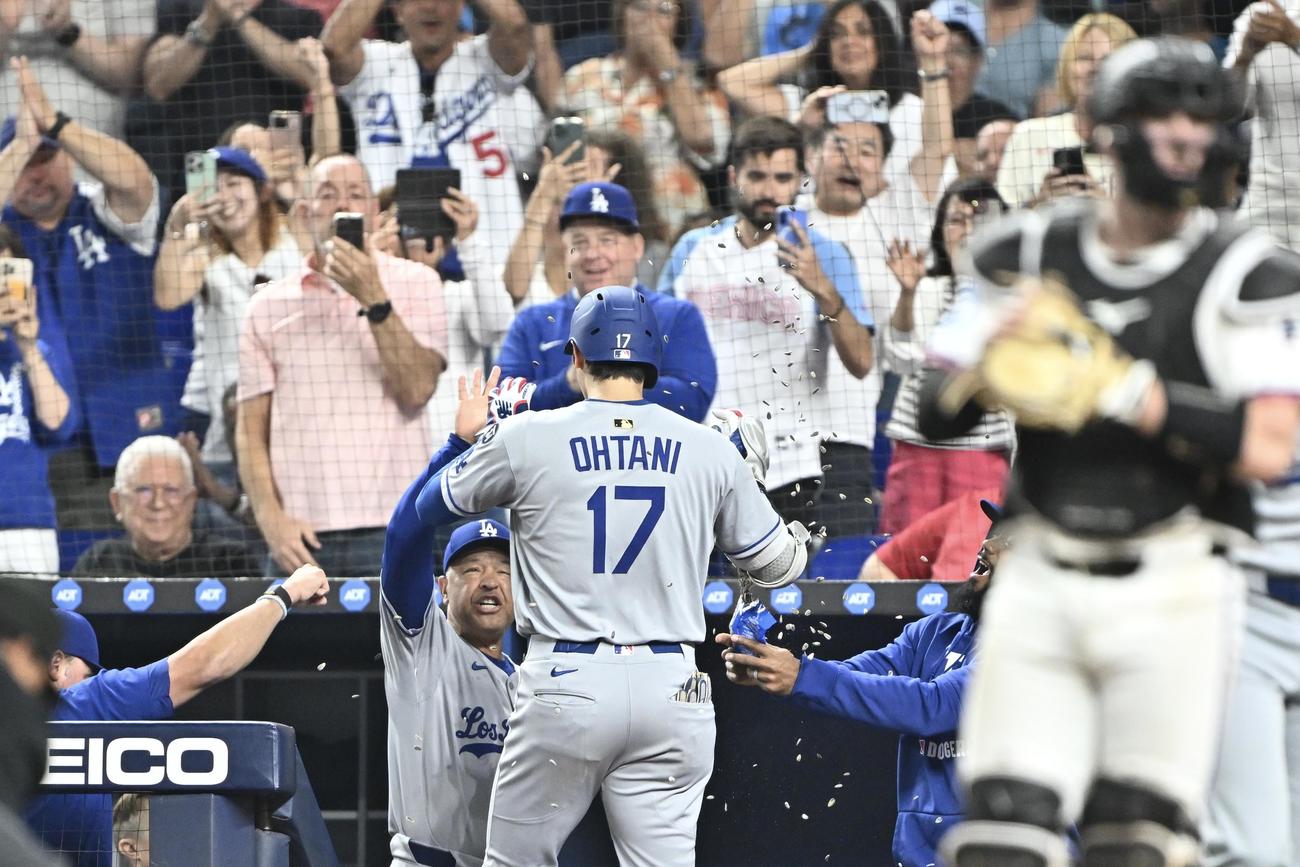マーリンズ対ドジャース　6回表ドジャース無死、ソロ本塁打を放った大谷（手前中央）は生還しひまわりの種を浴びながらロバーツ監督とタッチをかわす＝2025年5月6日　