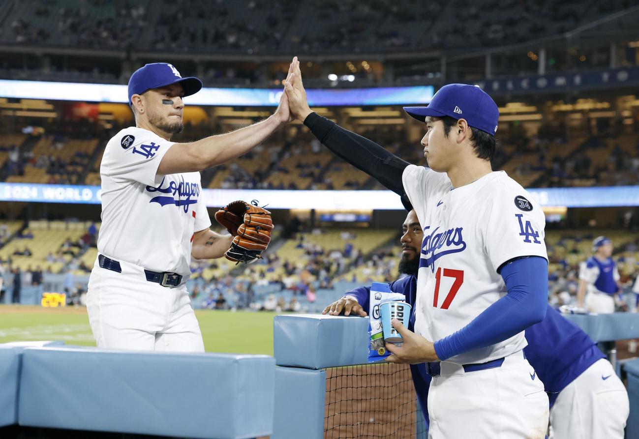 アスレチックス戦の9回に登板したロハス（左）とタッチするドジャース大谷（共同）