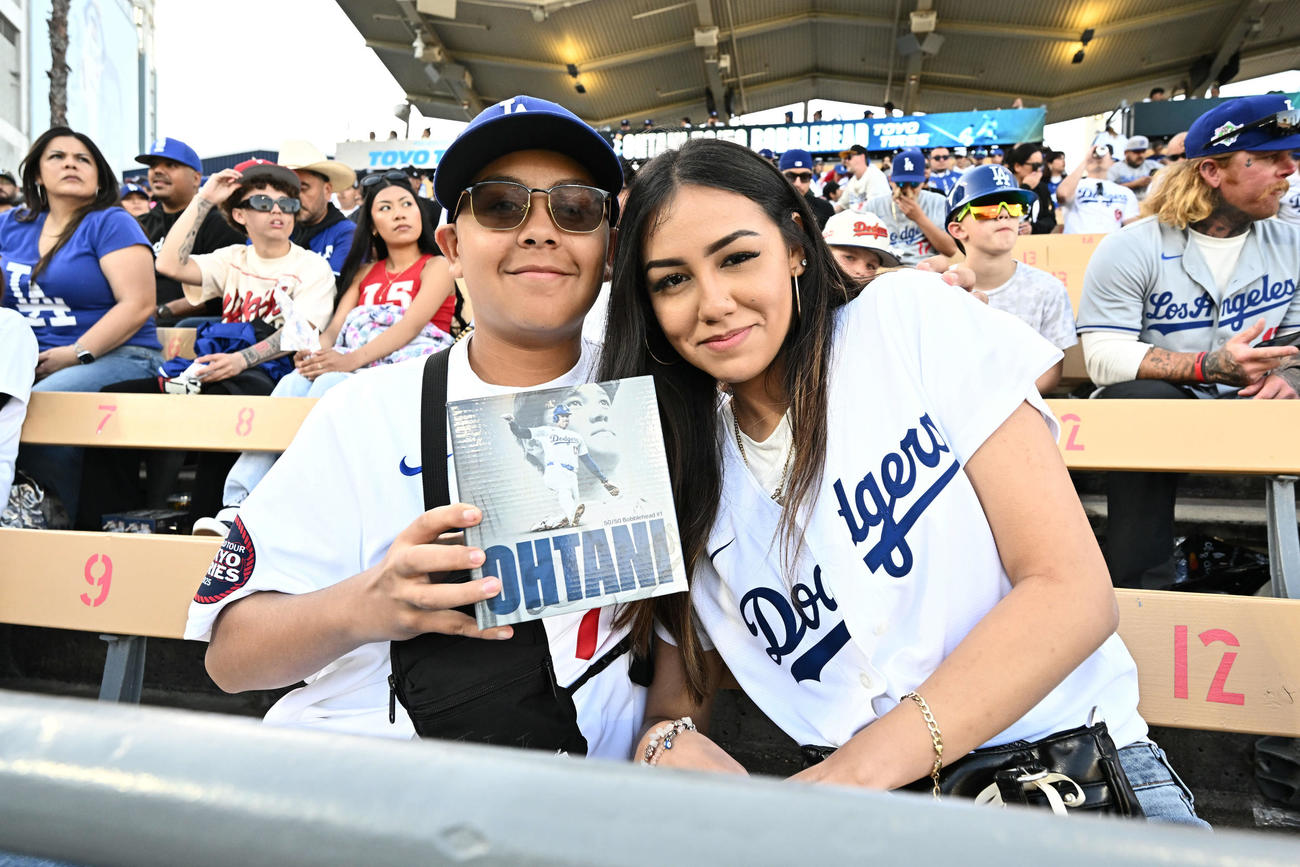 ドジャース対アスレチックス　ドジャース大谷のボブルヘッド人形を手に写真に納まるファン（撮影・滝沢徹郎）