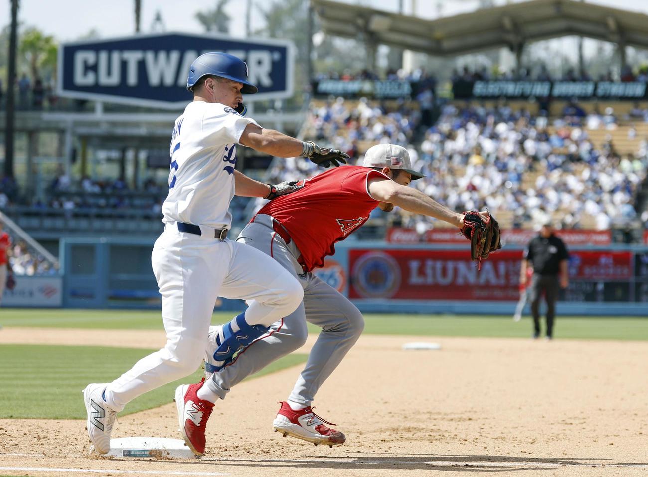ドジャース戦の6回、エドマンの一ゴロで一塁ベースカバーに入る際、交錯するエンゼルス菊池。右足首を痛めて負傷降板となる（共同）