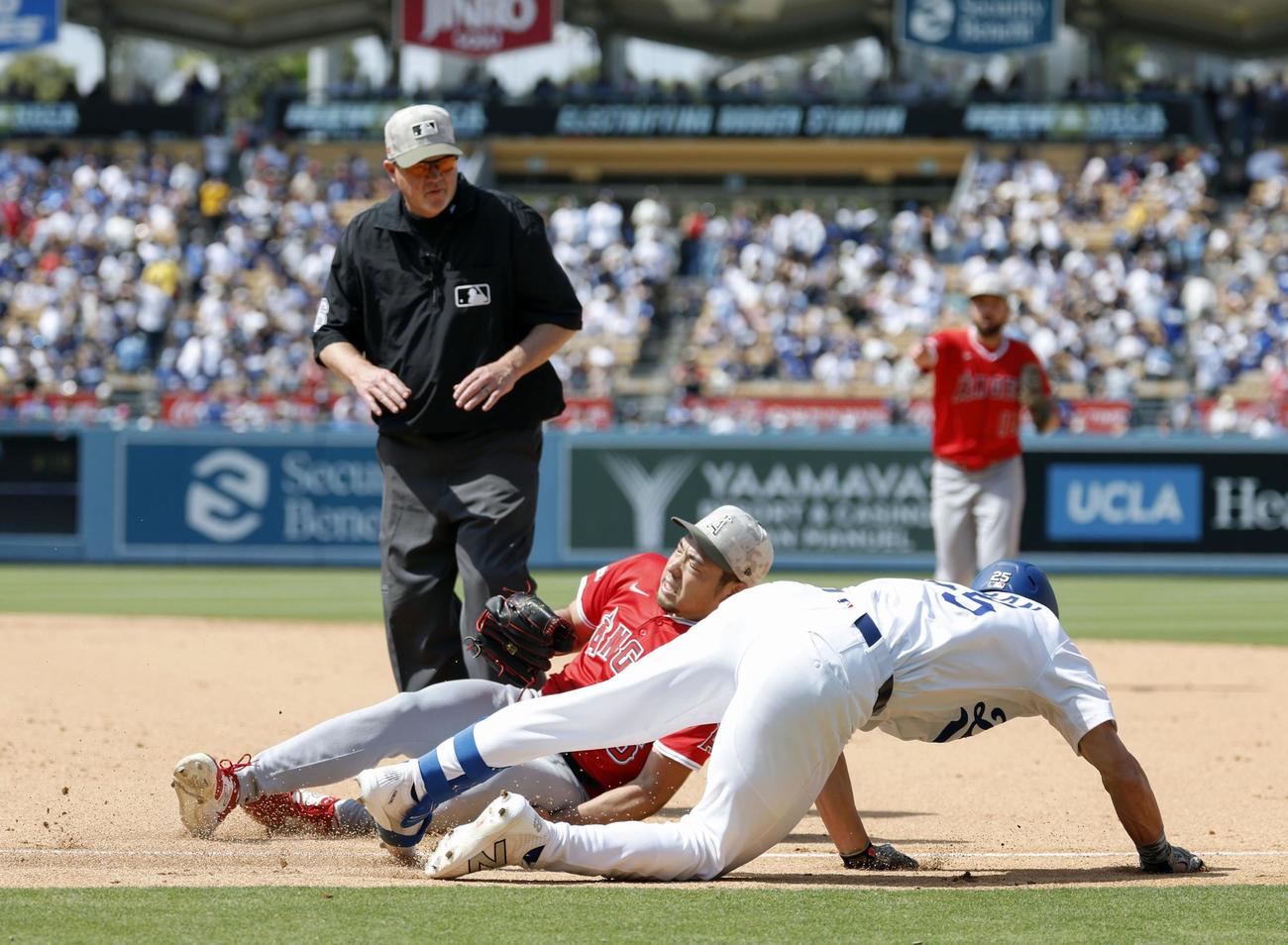 ドジャース戦の6回、エドマンの一ゴロで一塁ベースカバーに入る際、交錯するエンゼルス菊池。右足首を痛めて負傷降板となる（共同）