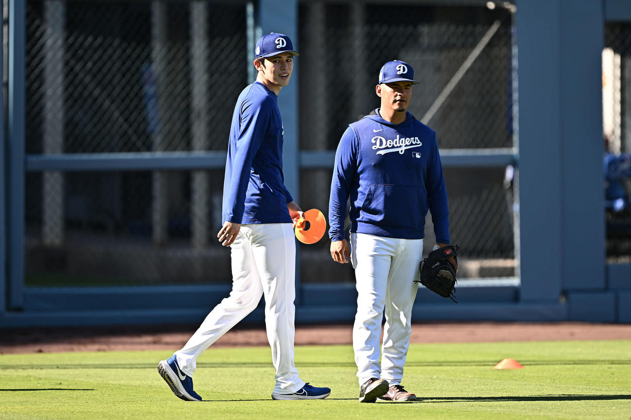 ドジャース対ダイヤモンドバックス　試合前練習で調整するドジャース佐々木（左）は笑顔を見せる（撮影・滝沢徹郎）
