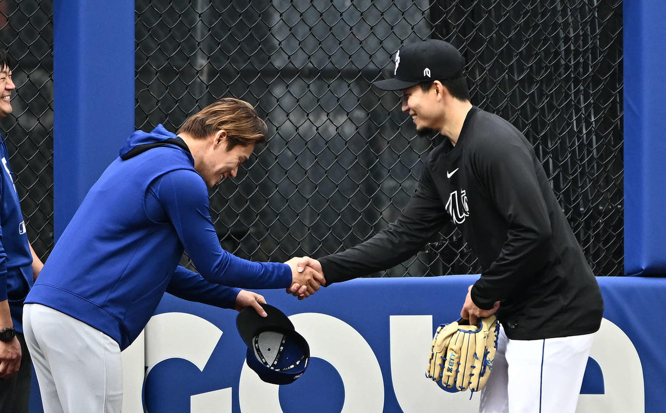 メッツ対ドジャース　試合前練習でドジャース山本（左）はメッツ千賀と握手を交わす（撮影・滝沢徹郎）